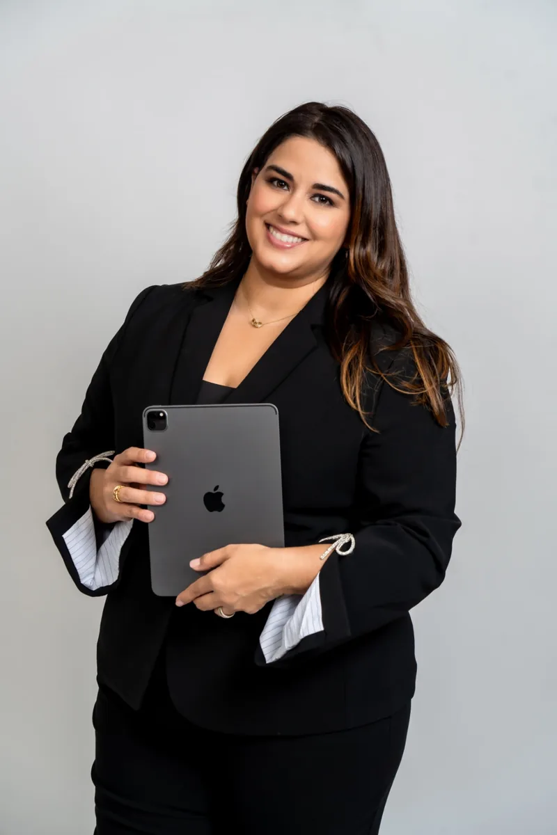 Celivic Rivera, fundadora de Crece Tu Estética, sonriendo con su tablet